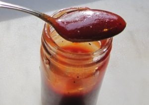 Honey barbecue sauce in jar with spoon.