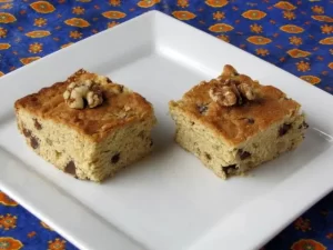 Two chocolate chip walnut bars on plate.