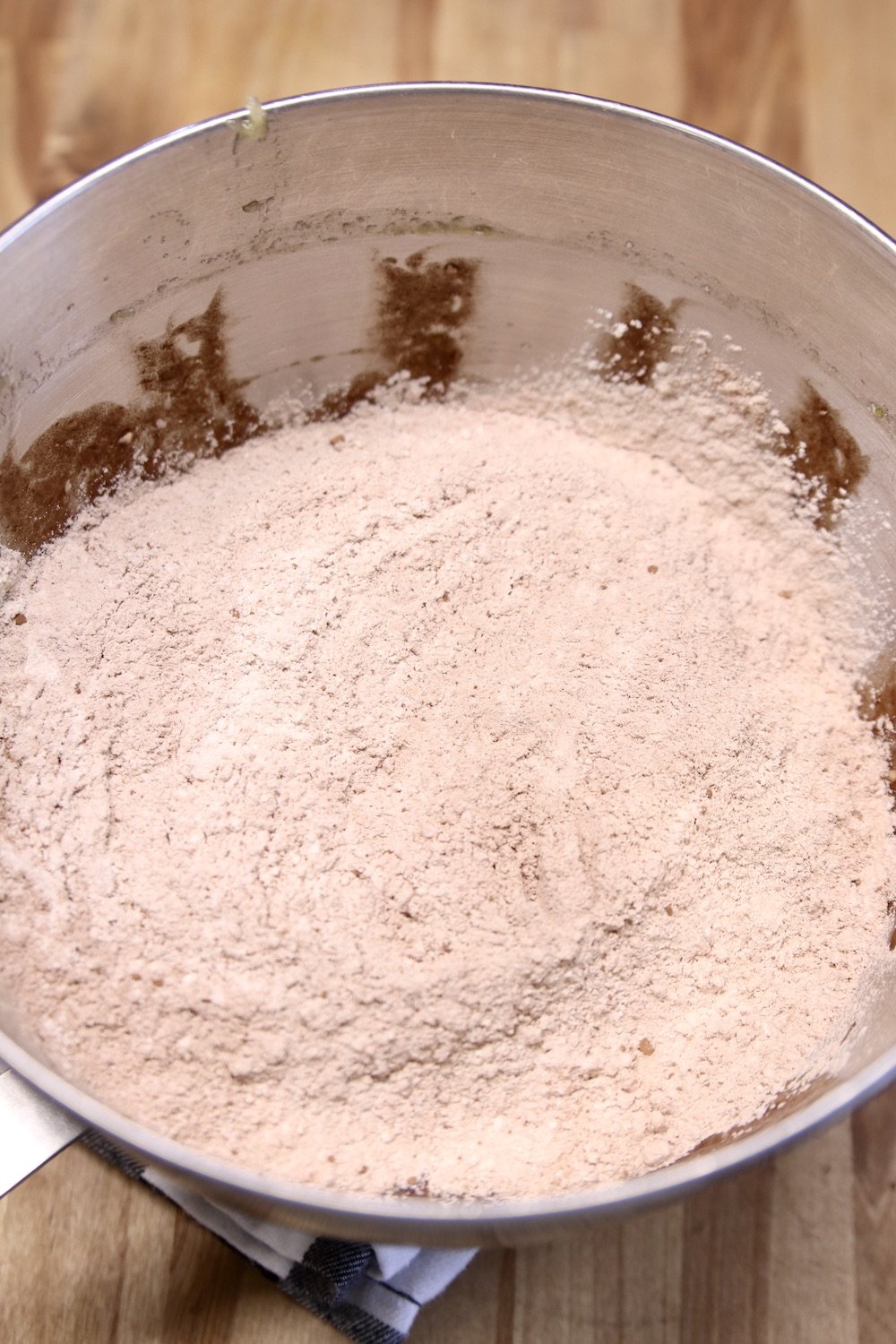 Dry ingredients added to banana bread batter in a mixing bowl