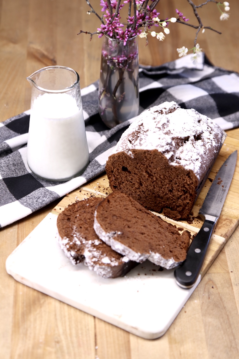 Chocolate banana bread with small milk jug and flowers