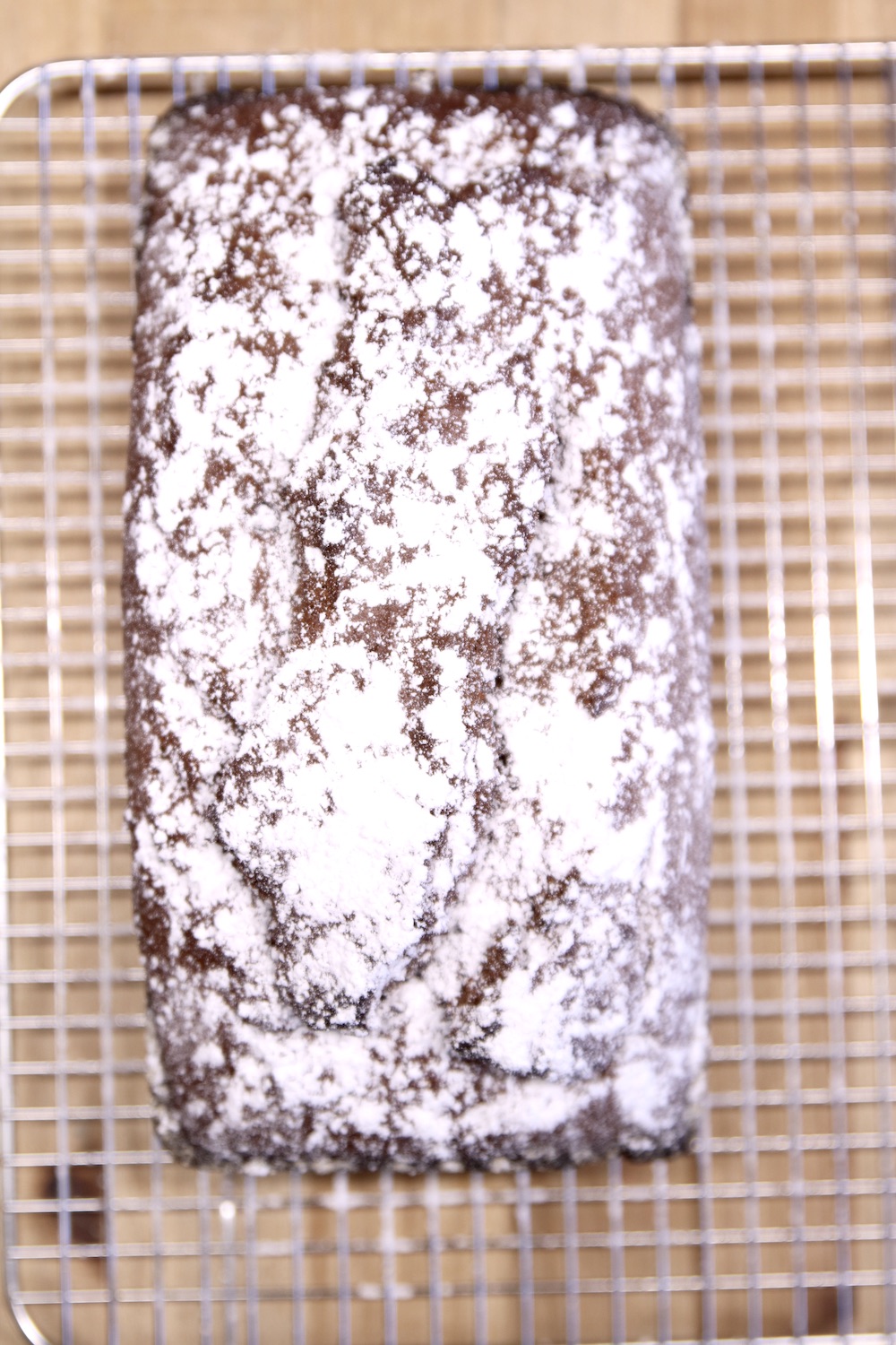 chocolate loaf on  a wire rack sprinkled with powdered sugar