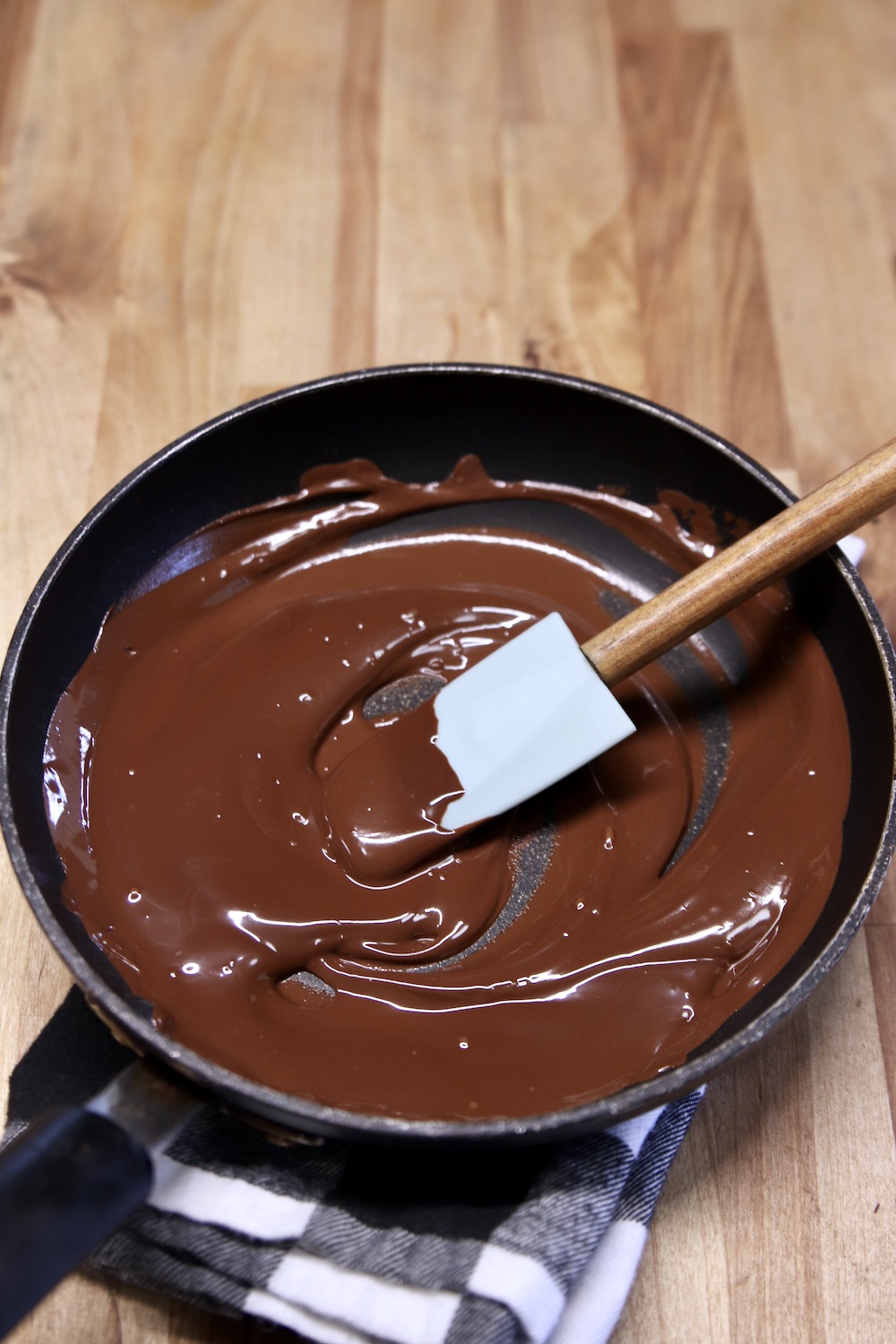 melted chocolate in a small skillet with a silicone spatula