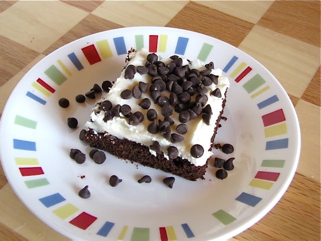 Brownie with Cream Cheese icing topped with chocolate chips on plate