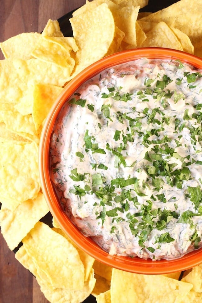 Orange bowl with spinach dip and tortilla chips