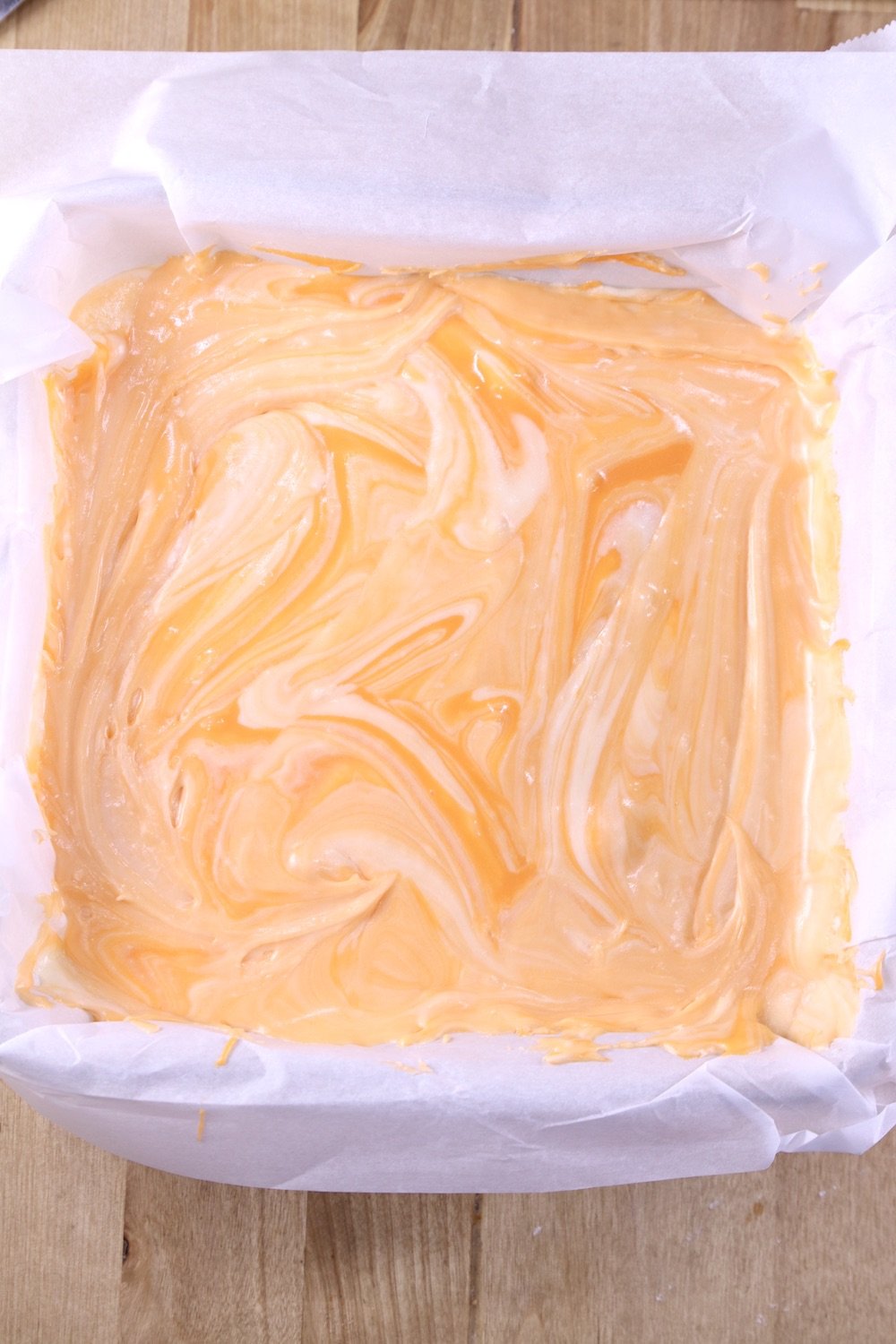 Creamsicle marbled fudge in a parchment lined pan, overhead view