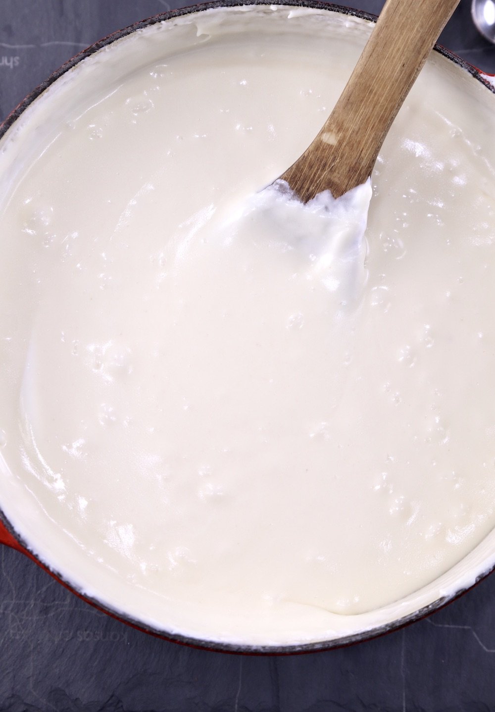 Vanilla Fudge mixture in a pan with wood spoon submerged