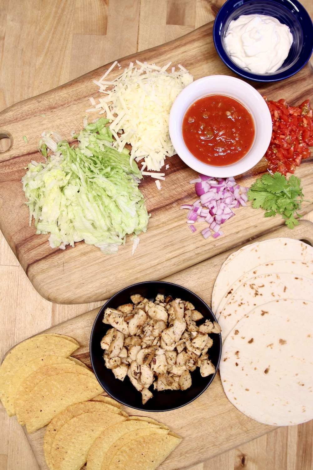 chicken tacos ingredients, lettuce, onion, cheese, salsa, chopped chicken, tortillas