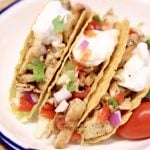 3 Grilled chicken tacos with sour cream and salsa on corn shells