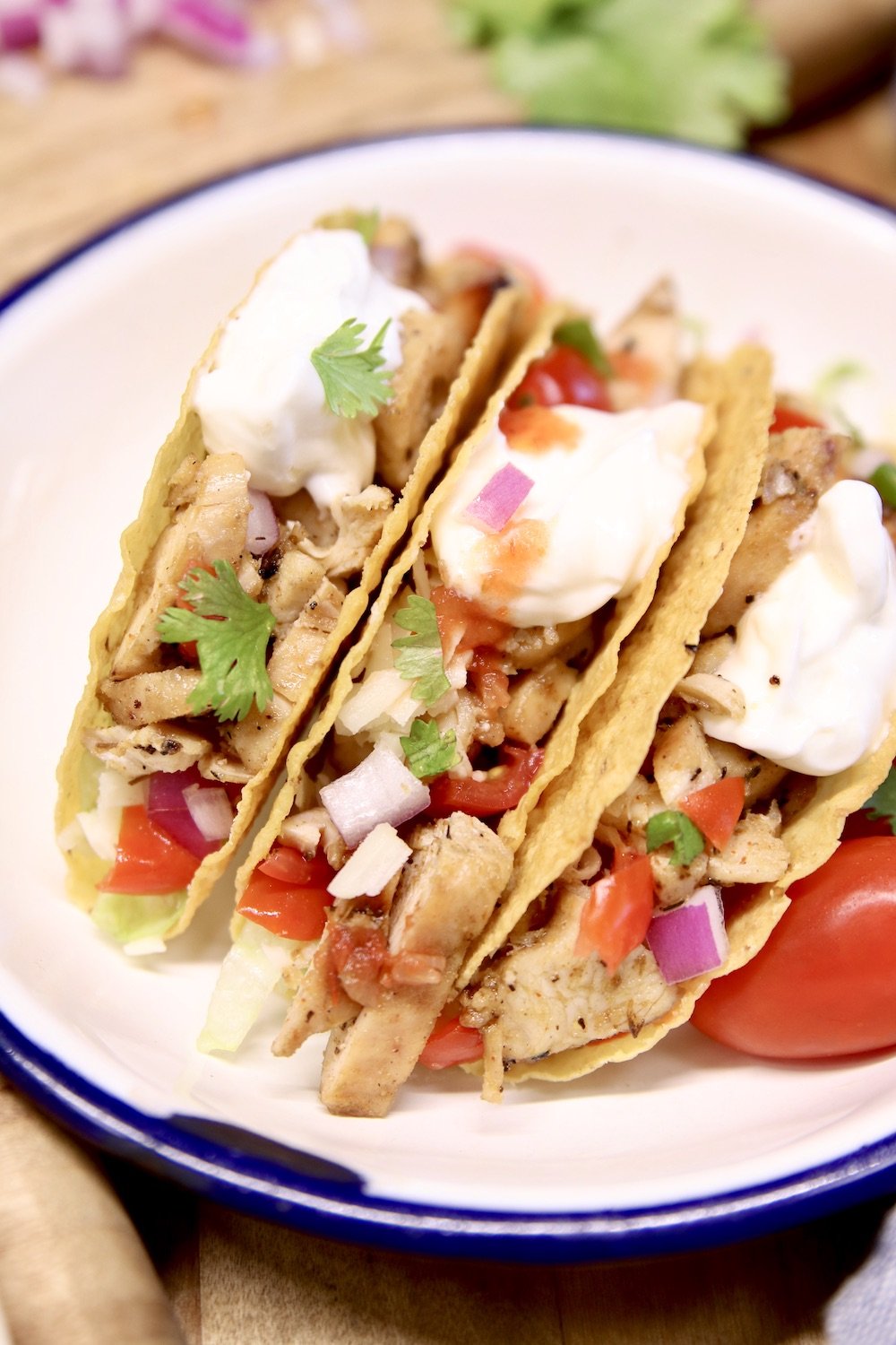 3 chicken tacos with sour cream and salsa