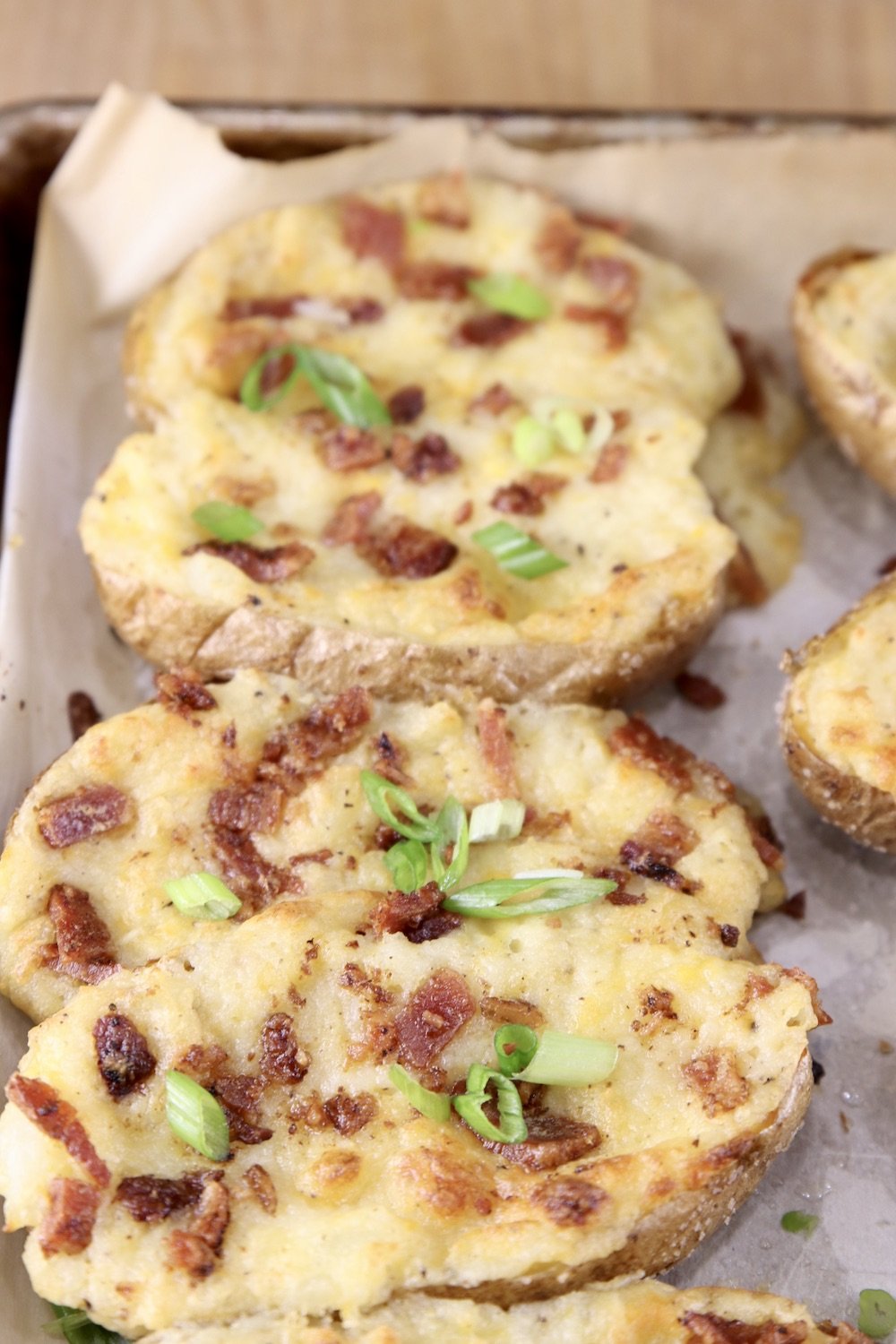tray of twice baked potato halves with bacon and green onions