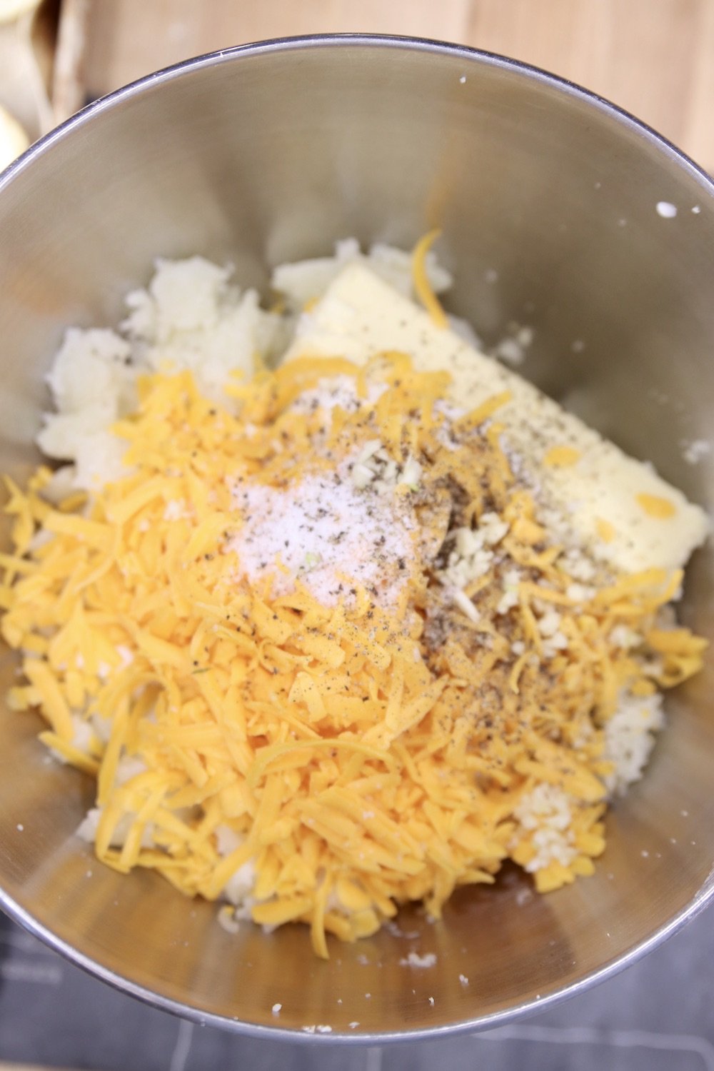 bowl of potatoes, cheese, sour cream for stuffed potatoes recipe