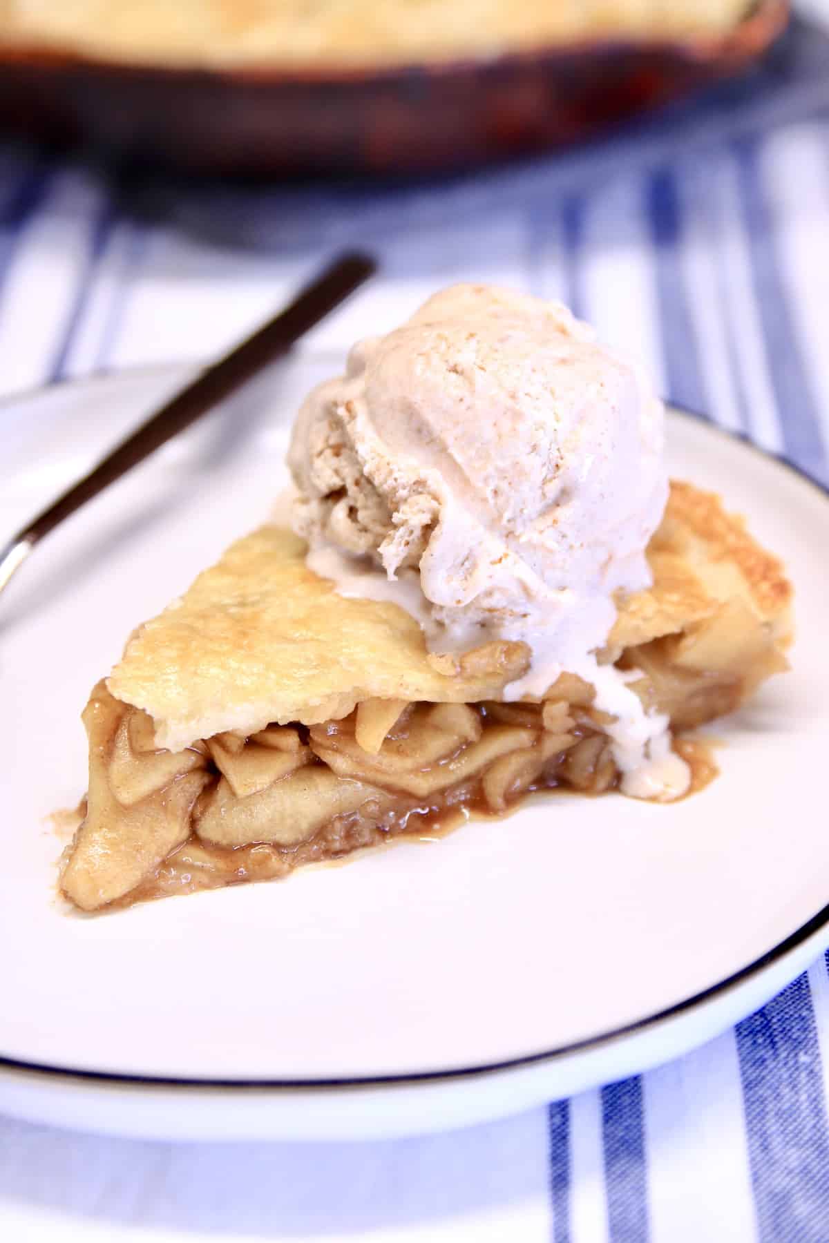 Slice of pie with ice cream on a plate.