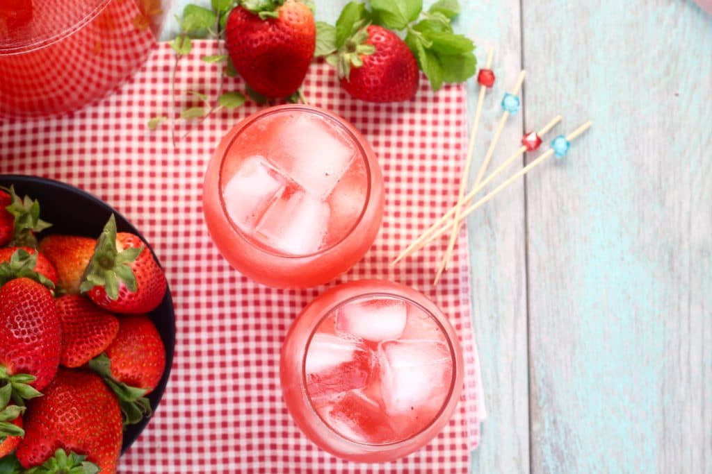 Easy Strawberry Wine Cocktail in stemless wine glasses with a bowl of strawberries 