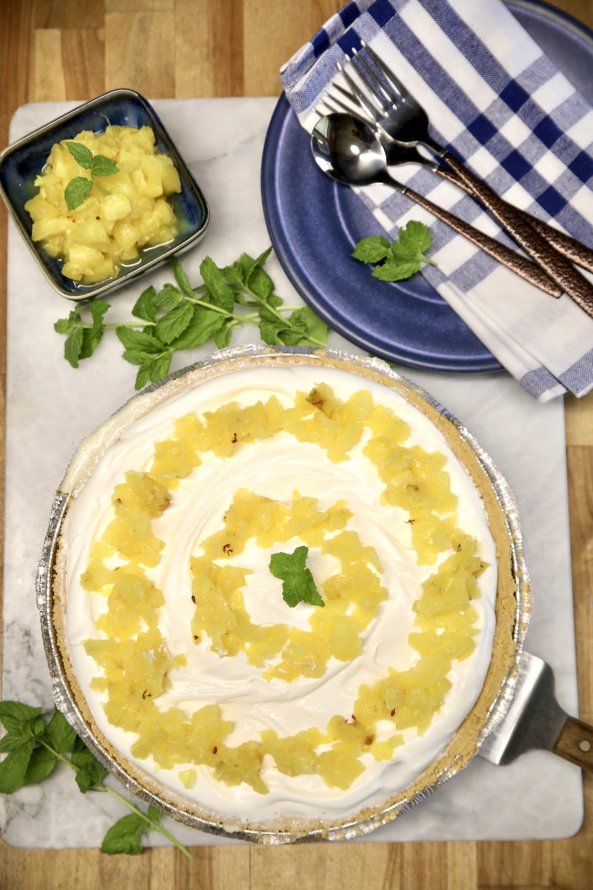 Pineapple Pie with bowl of pineapple, dessert plates, napkin, forks.
