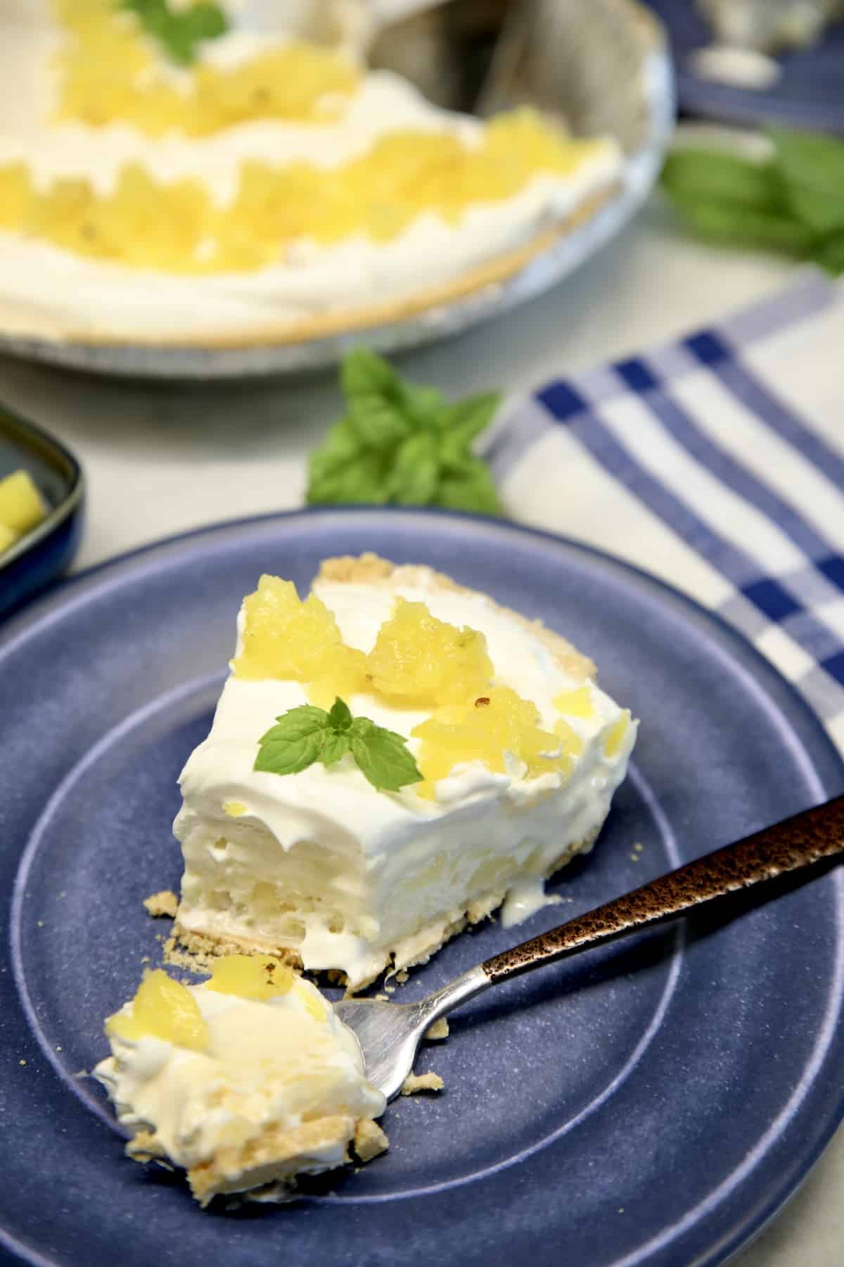 Slice of pineapple pie with a bite on a fork.