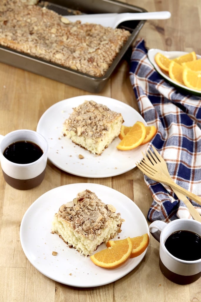 Almond Streusel Coffee Cake on 2 plates with coffee and sliced oranges