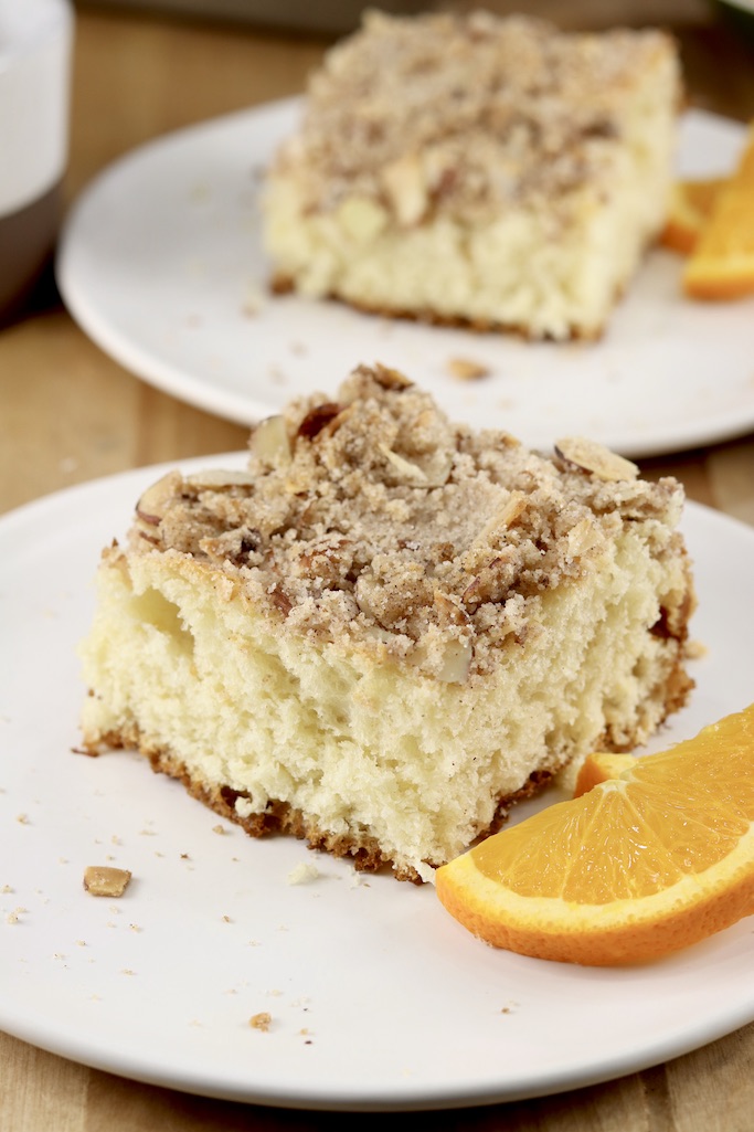 Slices of streusel coffee cake with orange slices - 2 plates