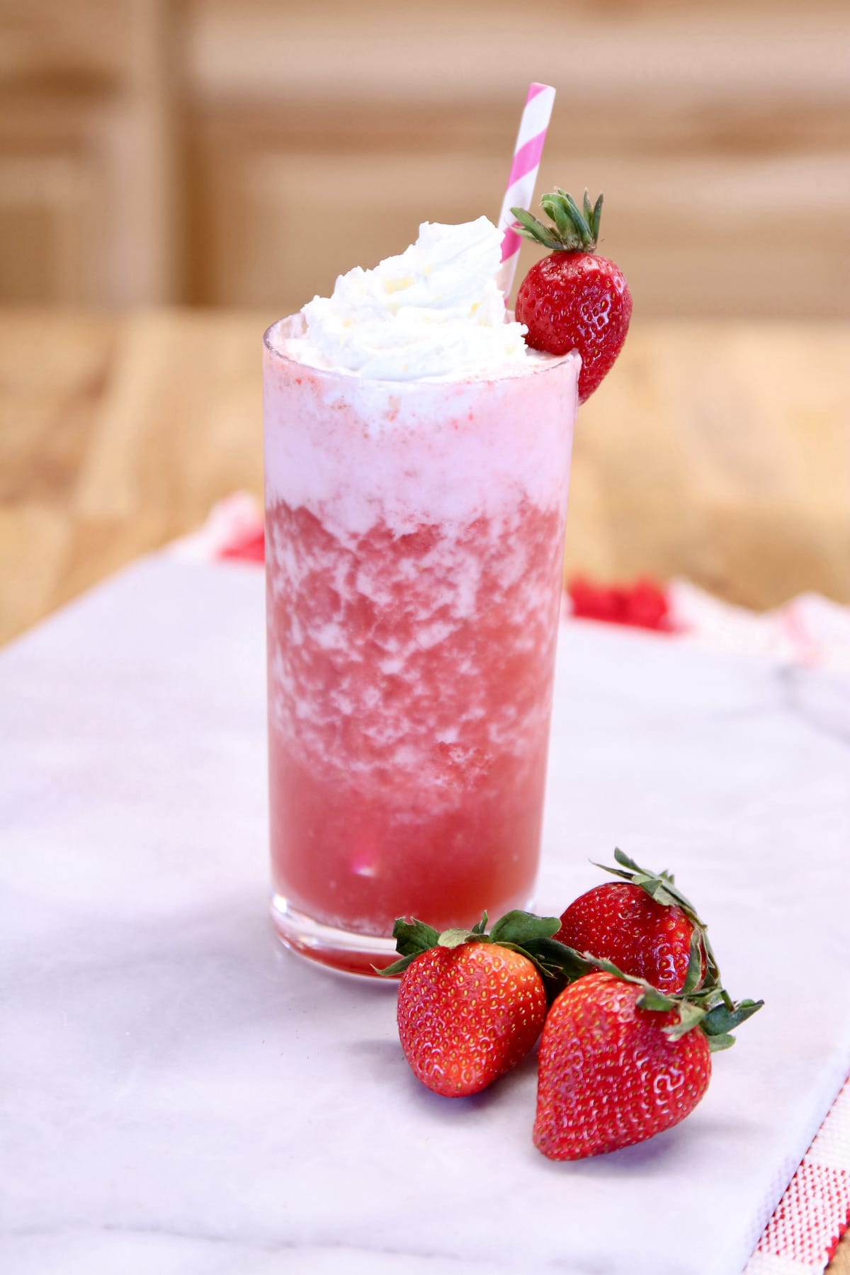 strawberry cocktail in glass with whipped cream with a strawberry.