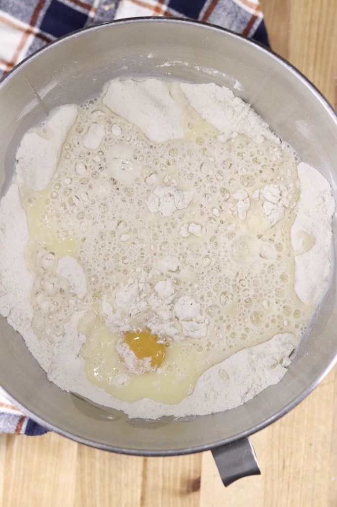 Bowl of flour, sugar, yeast, milk, eggs and butter for coffee cake