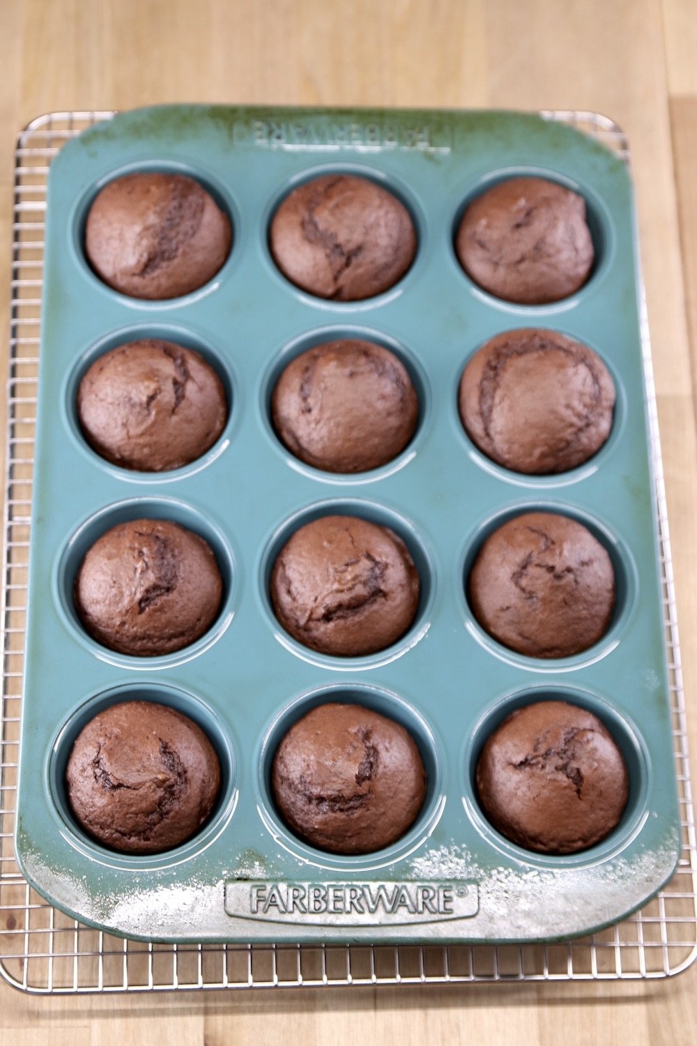 baked chocolate cupcakes in a blue cupcake tin
