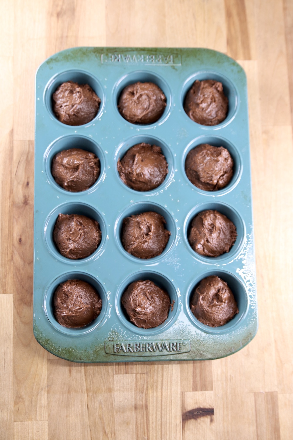 blue cupcake pan filled with chocolate batter