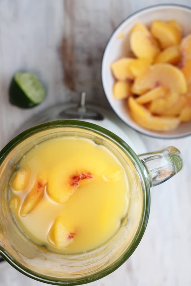 Blender with ingredients for frozen peach margaritas