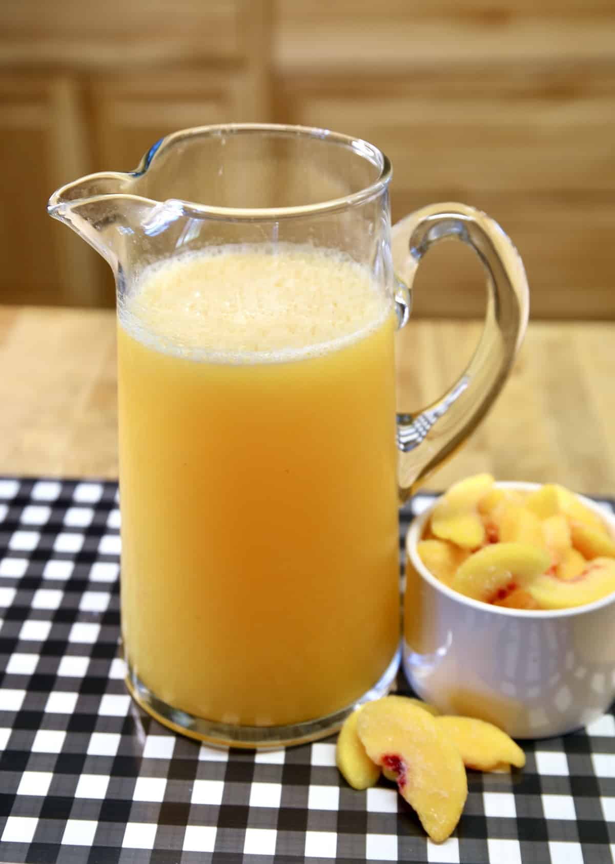 Pitcher of peach moscato punch, bowl of sliced peaches.