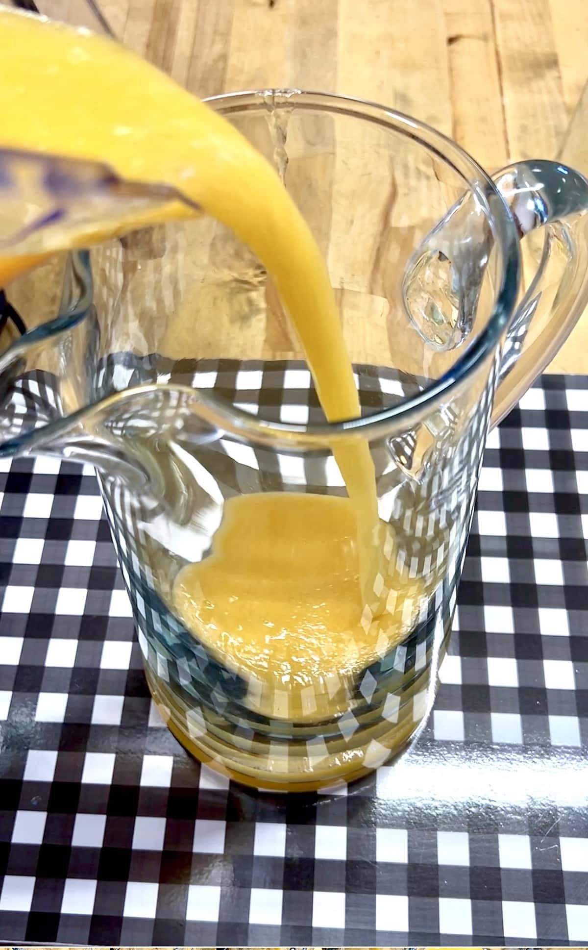 Pouring peach and wine mixture into a pitcher.