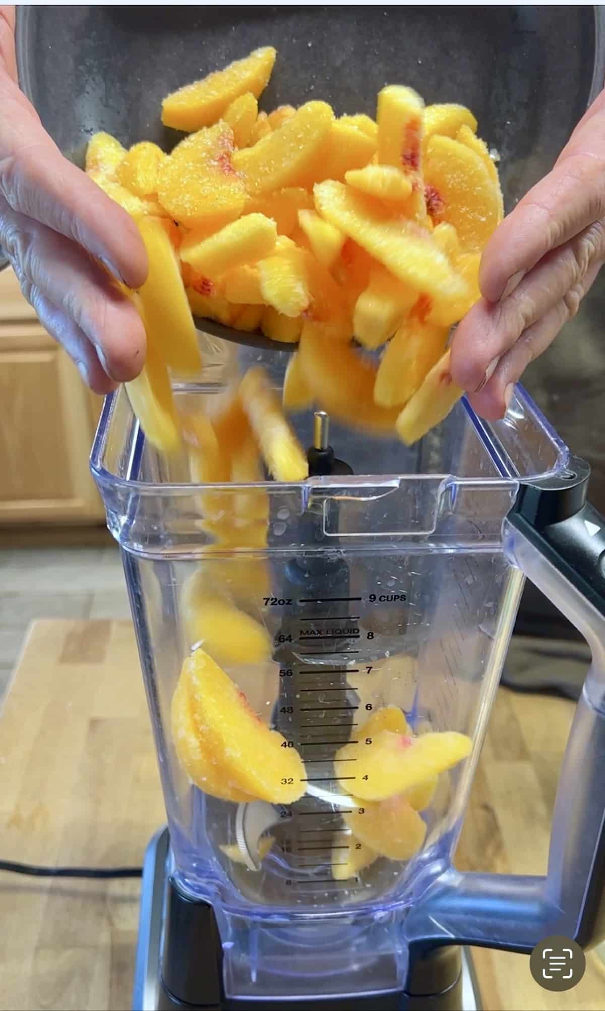 Pouring  frozen peaches into a blender for cocktail.
