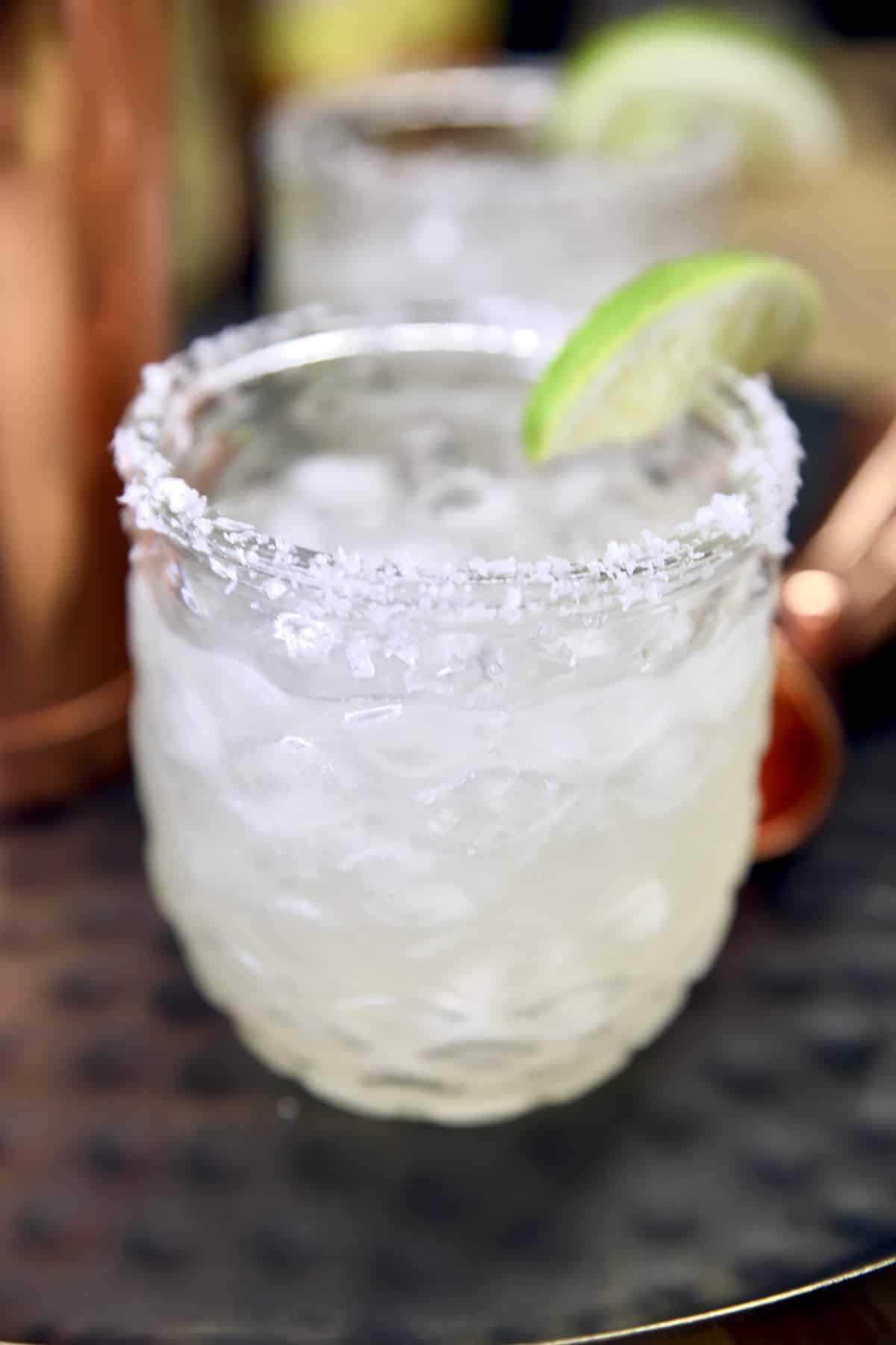 Margarita in a glass, salt rim and lime slice garnish.