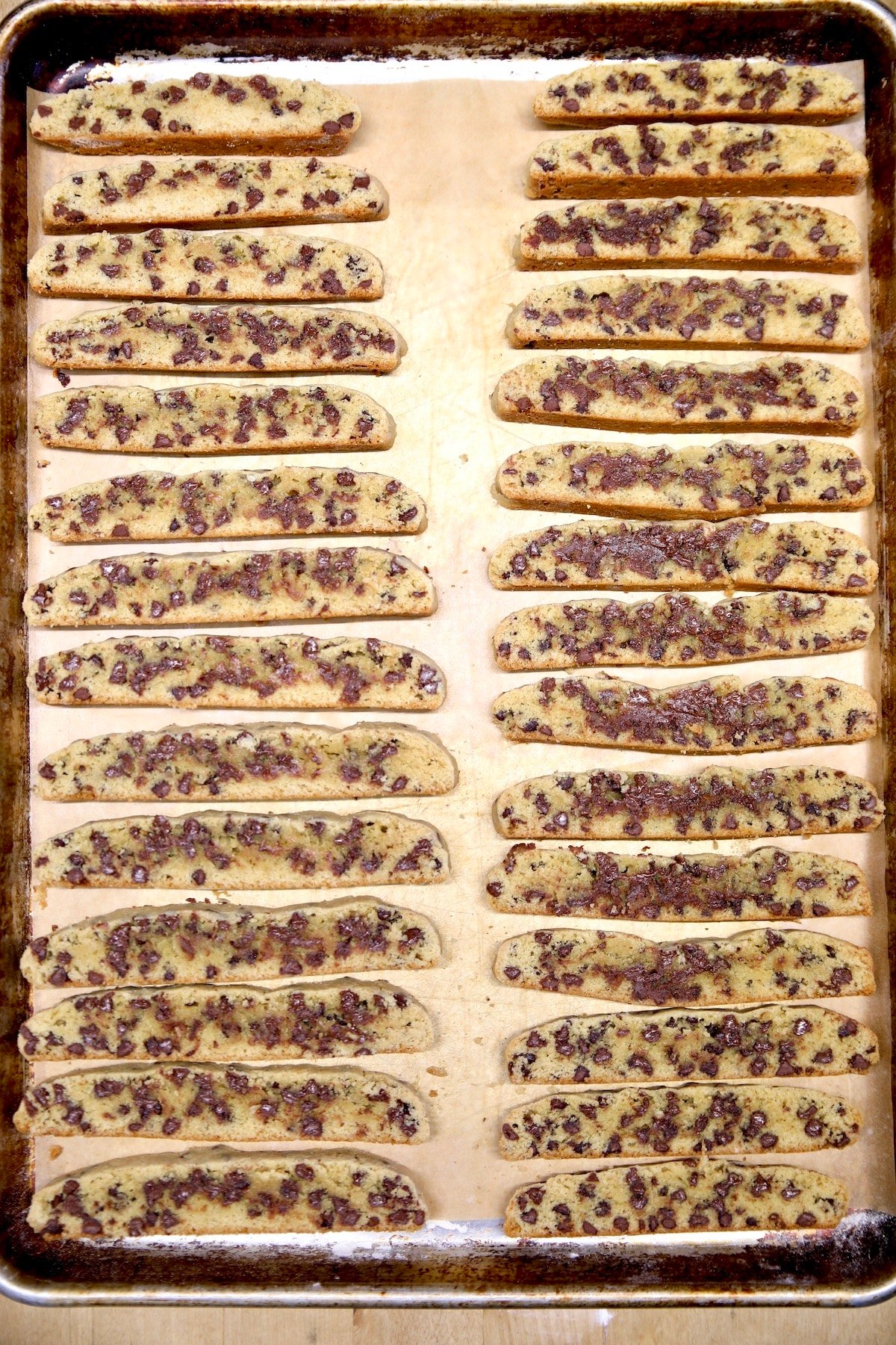 Cookie sheet with chocolate chip biscotti slices.
