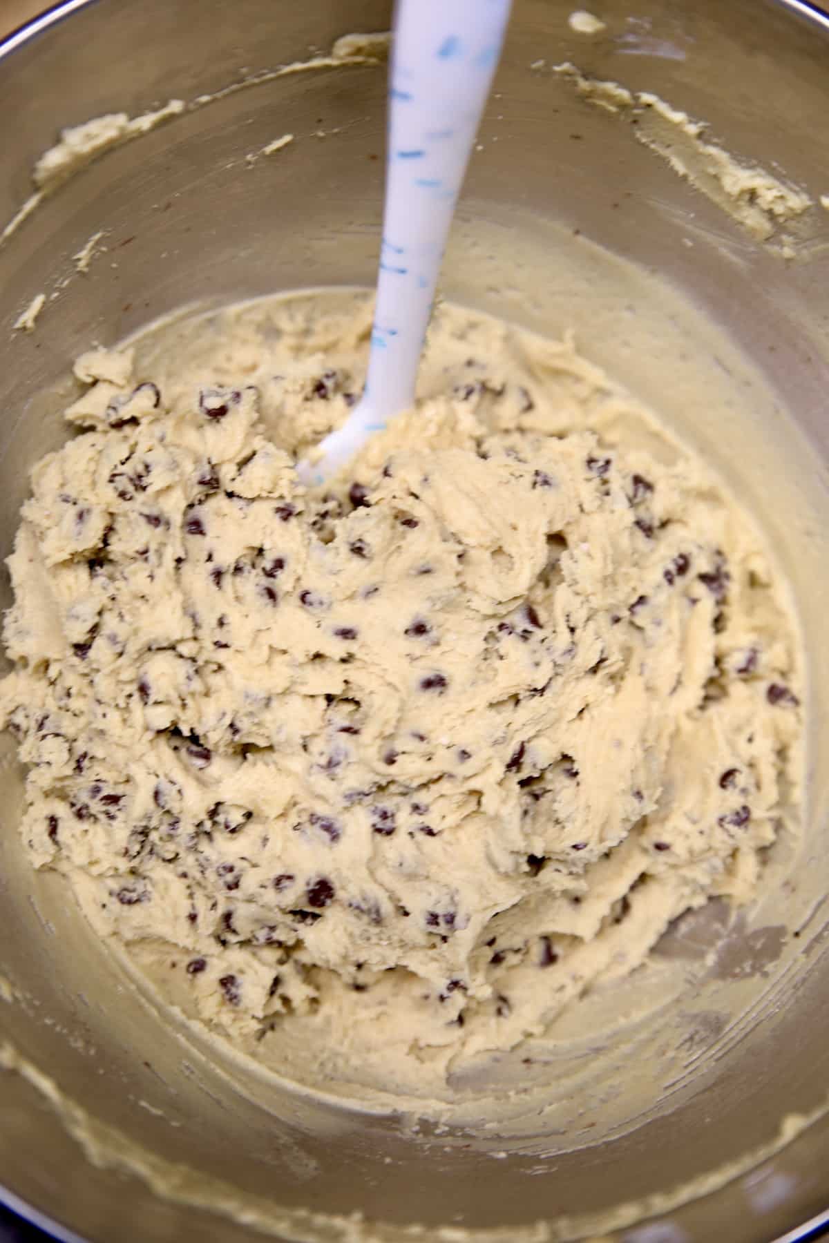 Chocolate chip biscotti dough in a bowl with silicone spatula.
