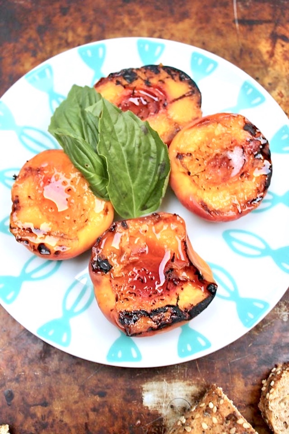 grilled peaches cut in half with fresh basil