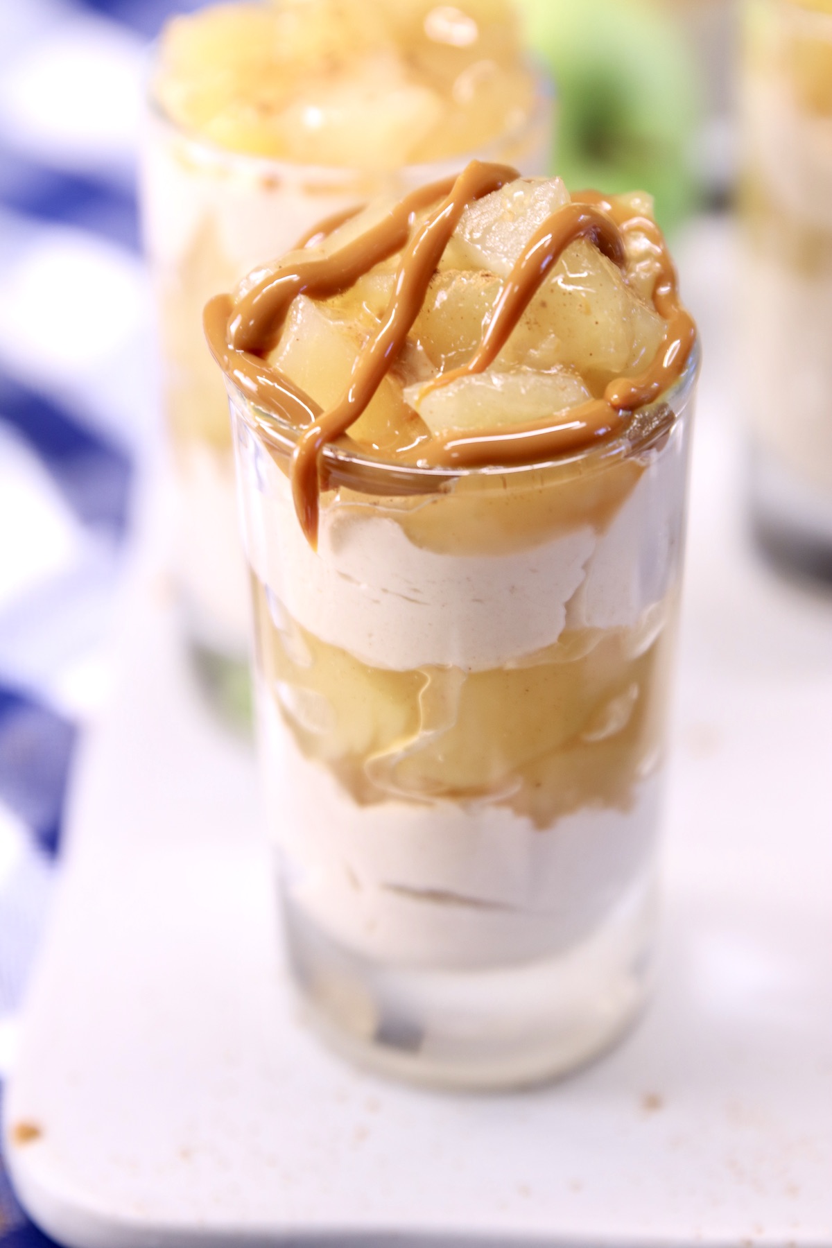 individual glass of apple cinnamon cheesecake with caramel drizzle