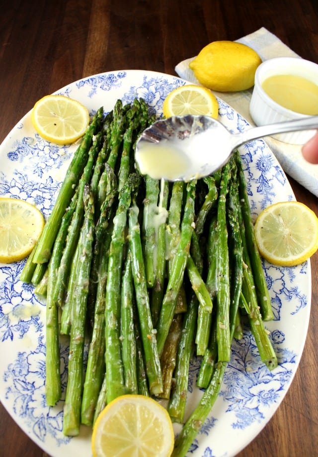 Drizzling Lemon Sauce over Garlic Roasted Asparagus from MissintheKitchen.com