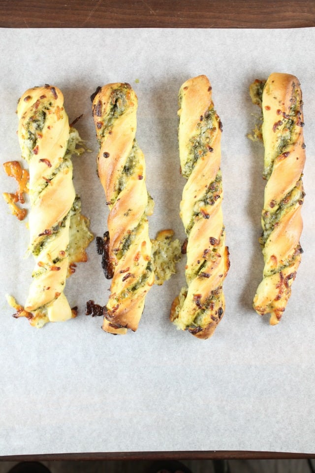 Cheesy Pesto Breadsticks are soft and filled with delicious pesto and ooey gooey cheese. Recipe from MissintheKitchen.com