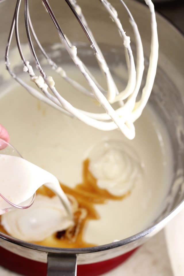 Adding vanilla and cream to Mini Turtle Cheesecake filling | MissintheKitchen.com