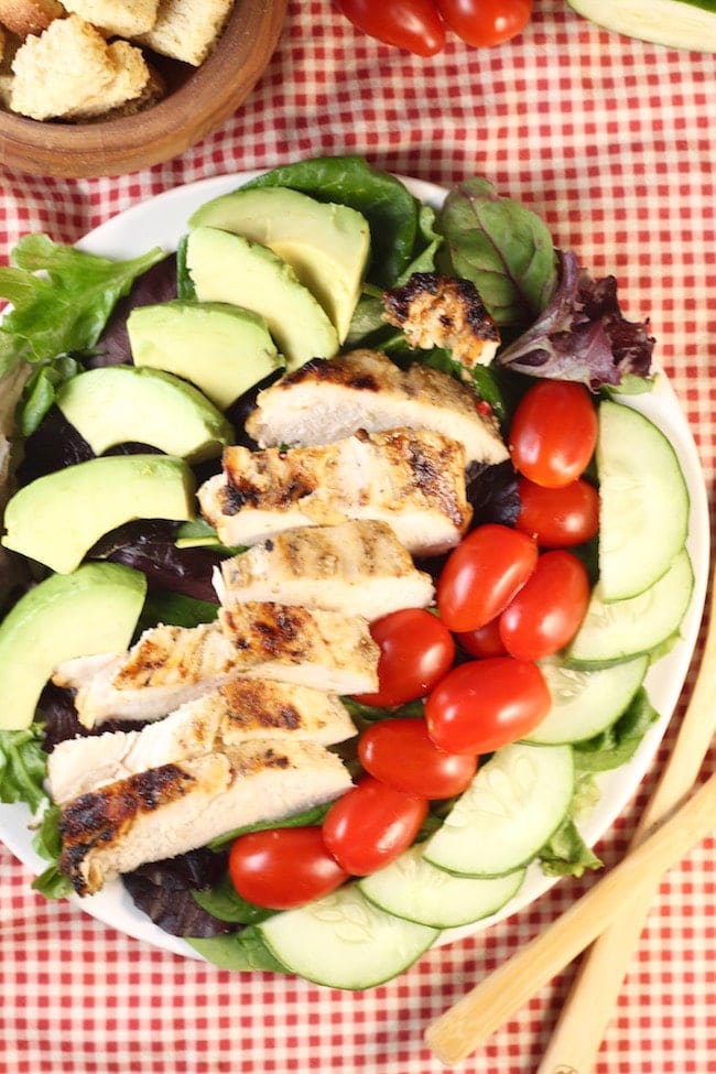Grilled-Chicken-Salad-on-a-plate-with-tomatoes-avocado-cucumber- placed-on-napkin
