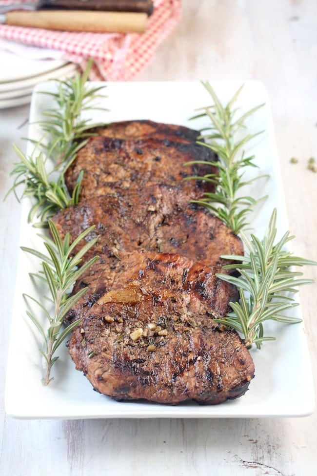 Grilled Balsamic Pork Chops on a white Platter with fresh rosemary