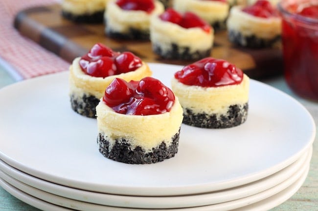 Mini Cherry Cheesecakes on a stack of plates