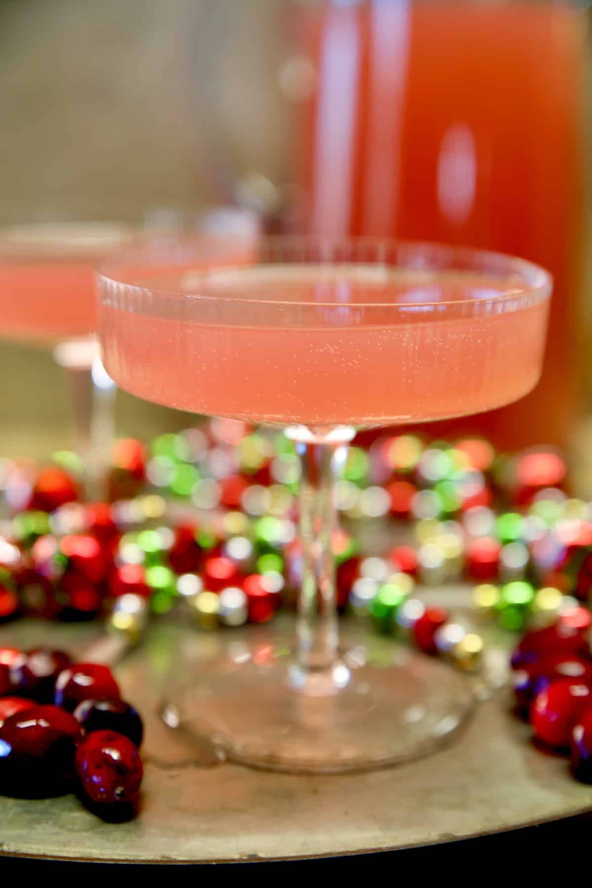 Cosmopolitan party punch on a platter with holiday beads.