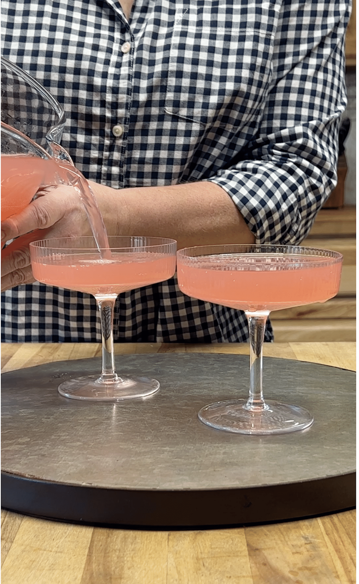 Pouring pink punch into cocktail glasses.