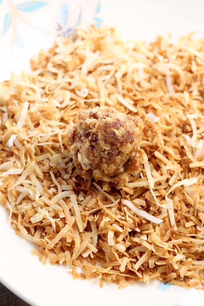 rolling date balls in toasted coconut