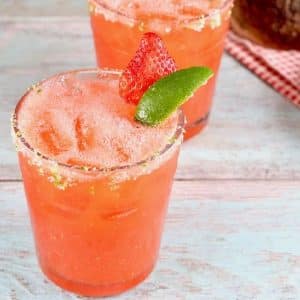 Strawberry Margaritas in a glass with lime garnish.