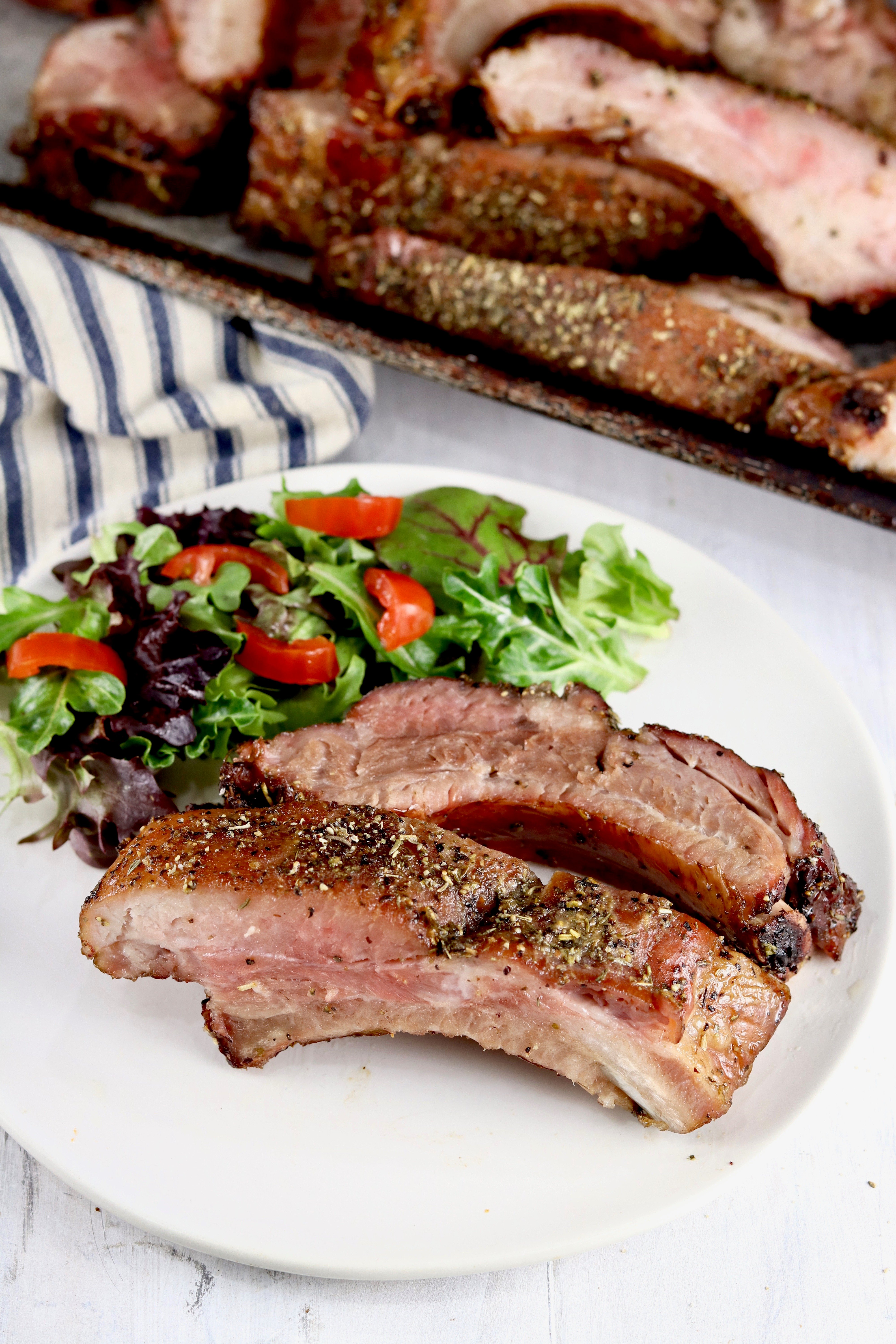 Smoked Baby Back Ribs on a plate with green salad