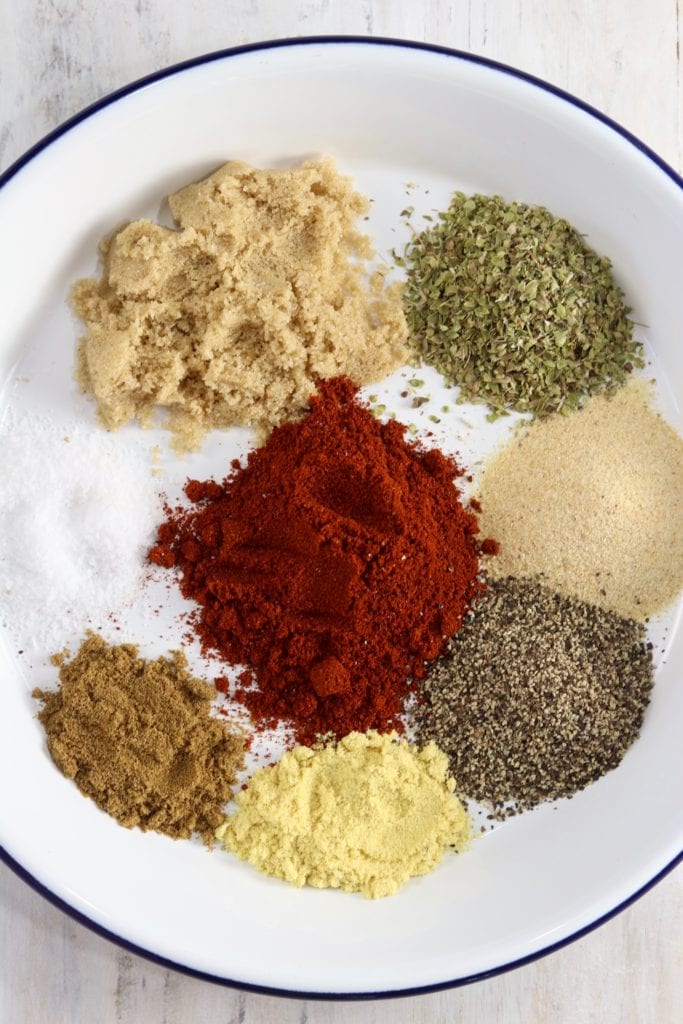 Paprika, garlic, oregano, pepper and spices for Blackened Seasoning on a white plate