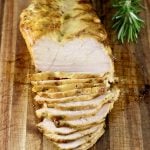 Mustard BBQ Chicken breast, sliced on cutting board with fresh rosemary