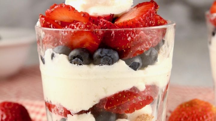 Cheesecake Parfaits in a glass with whipped cream on top