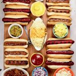 Board with grilled hot dogs and toppings