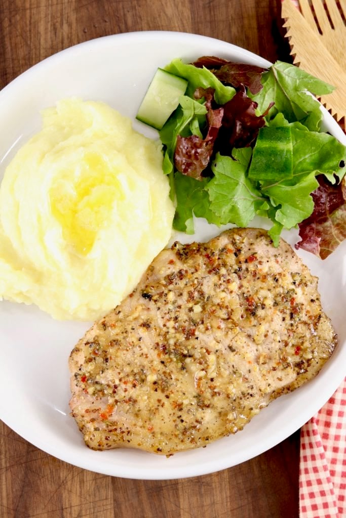 Plate of Italian Pork Chops with mashed potatoes and salad
